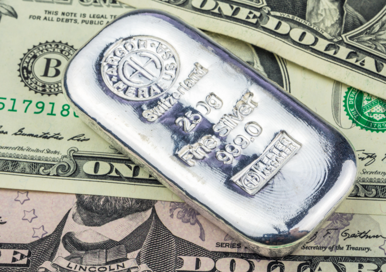 Image of a 250 g silver bar on a pile of US currency